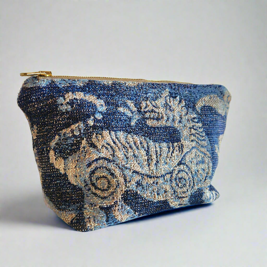 Blue velvet pouch with intricate patterns on a white surface